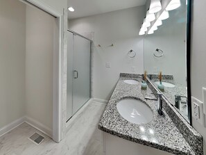 A modern bathroom with two sinks, a large mirror, and a shower area. - Shady Beaches | Waterfront Haven, Private Pier (Surf City)