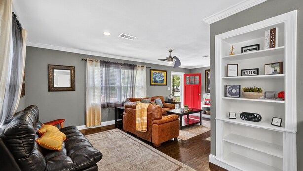 A living room with a black leather sofa, a brown leather sofa, a coffee table, and a bookshelf. - Cozy Moultrie Home With Backyard Retreat 3 Bedroom Home (Moultrie)
