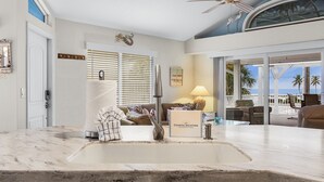 A modern kitchen with a large marble countertop, a built-in sink, and a ceiling fan. - 5550 Palmetto Paradise: 3br W/ Gulf Views, Heated Pool 3 Bedroom Home (Fort Myers Beach)