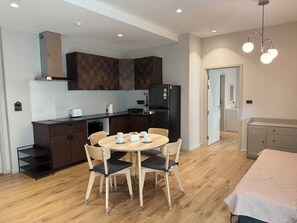 Departamento familiar, vista a la alberca | Cocina privada | Refrigerador con congelador, microondas y parrilla de estufa 