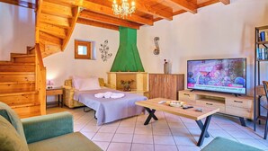 A cozy room with a wooden staircase, a bed with a green canopy, a television, and a bookshelf. - Villa Amarilda - Private Pool Garden in Corfu (Corfu)