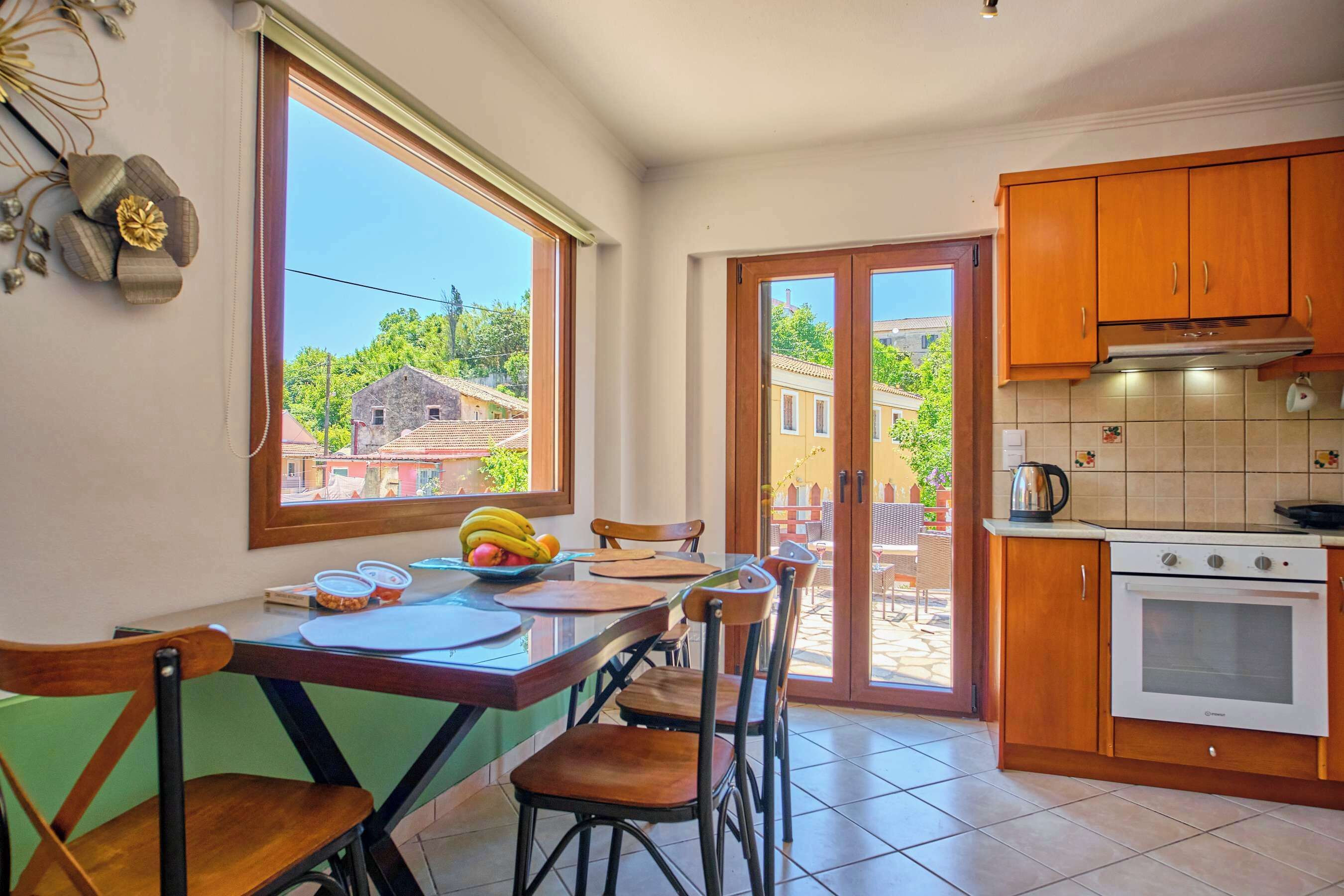 A kitchen with wooden cabinets, a stove, and a dining area with chairs and a table.