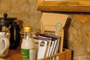 Una bandeja de madera con una bolsa de café, una taza y una botella.