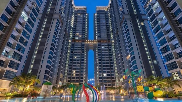 Un immeuble résidentiel de grande hauteur doté d’un atrium central, de nombreux étages et d’un élément décoratif aquatique en premier plan.