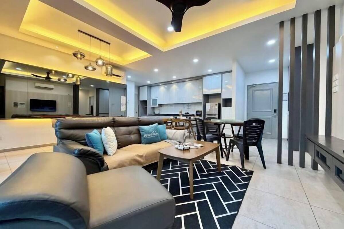 A modern living room with a sofa, coffee table, and dining area.
