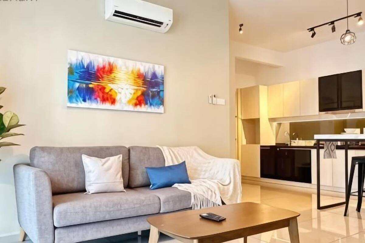 A living room with a sofa, a coffee table, and a TV.