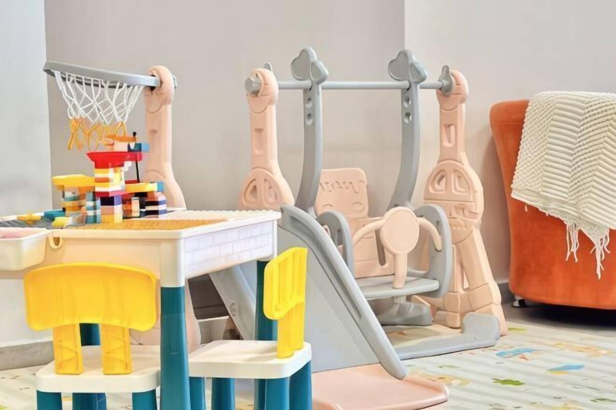A play area with a table, chairs, and a toy basketball hoop.