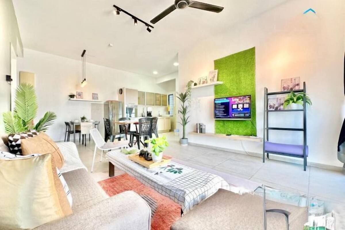 A modern living room with a sofa, coffee table, and TV. There is a dining area with chairs and a table.
