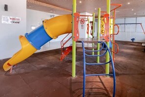A playground with a slide and climbing structures. - Atlantis Residences Melaka by HeyStay Management (Melaka)