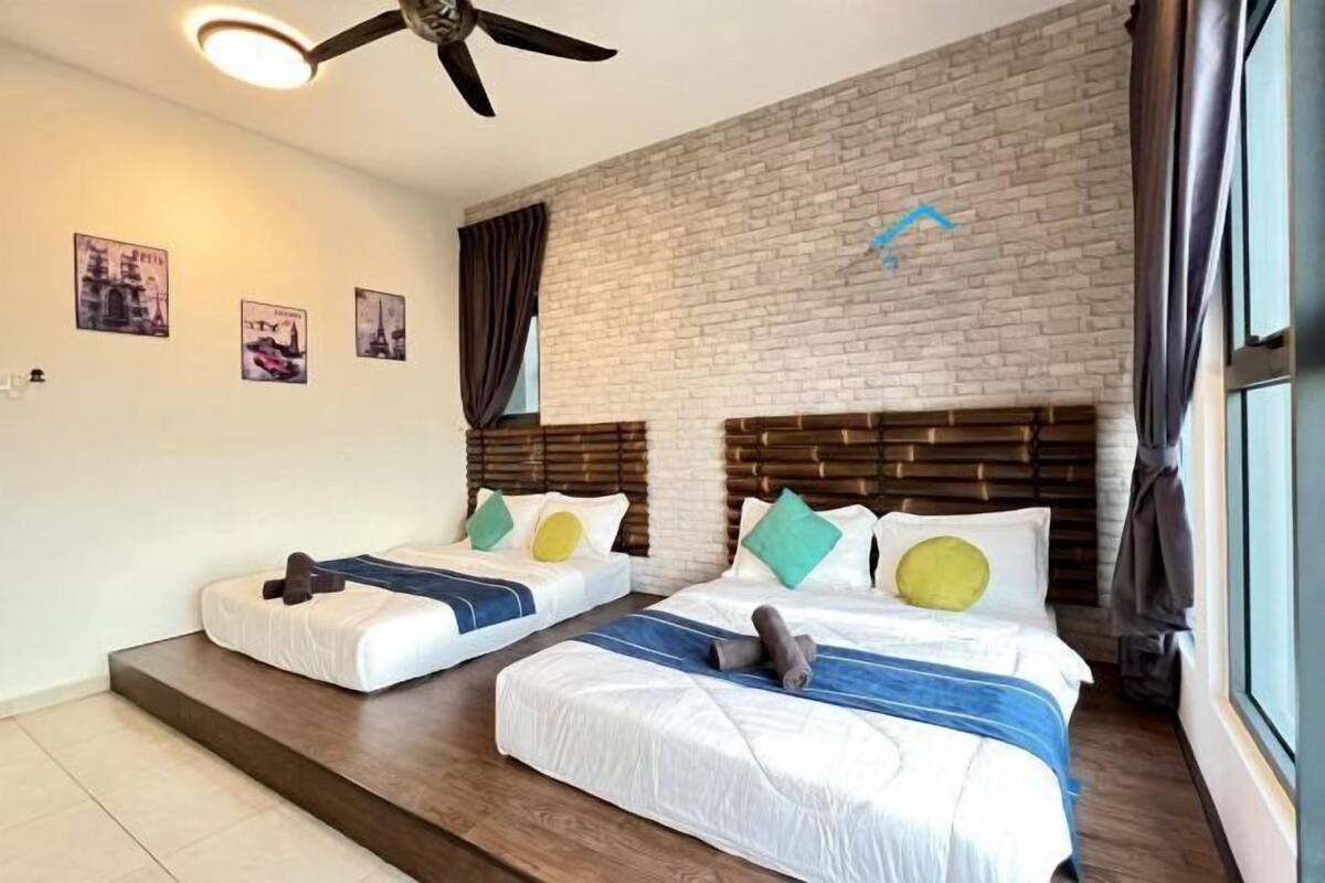 A hotel room with two beds, a brick wall, and a ceiling fan.