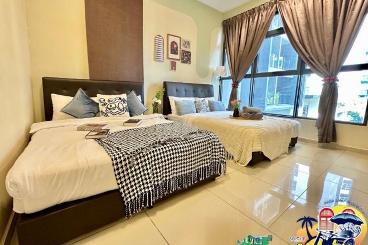 Una habitación de hotel con dos camas, un ventanal con cortinas y decoración en las paredes.