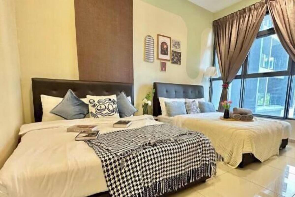 A hotel room with two beds, a large window with curtains, and wall art.