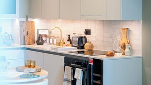 A modern kitchen with a white countertop, a built-in oven, and various kitchen appliances.