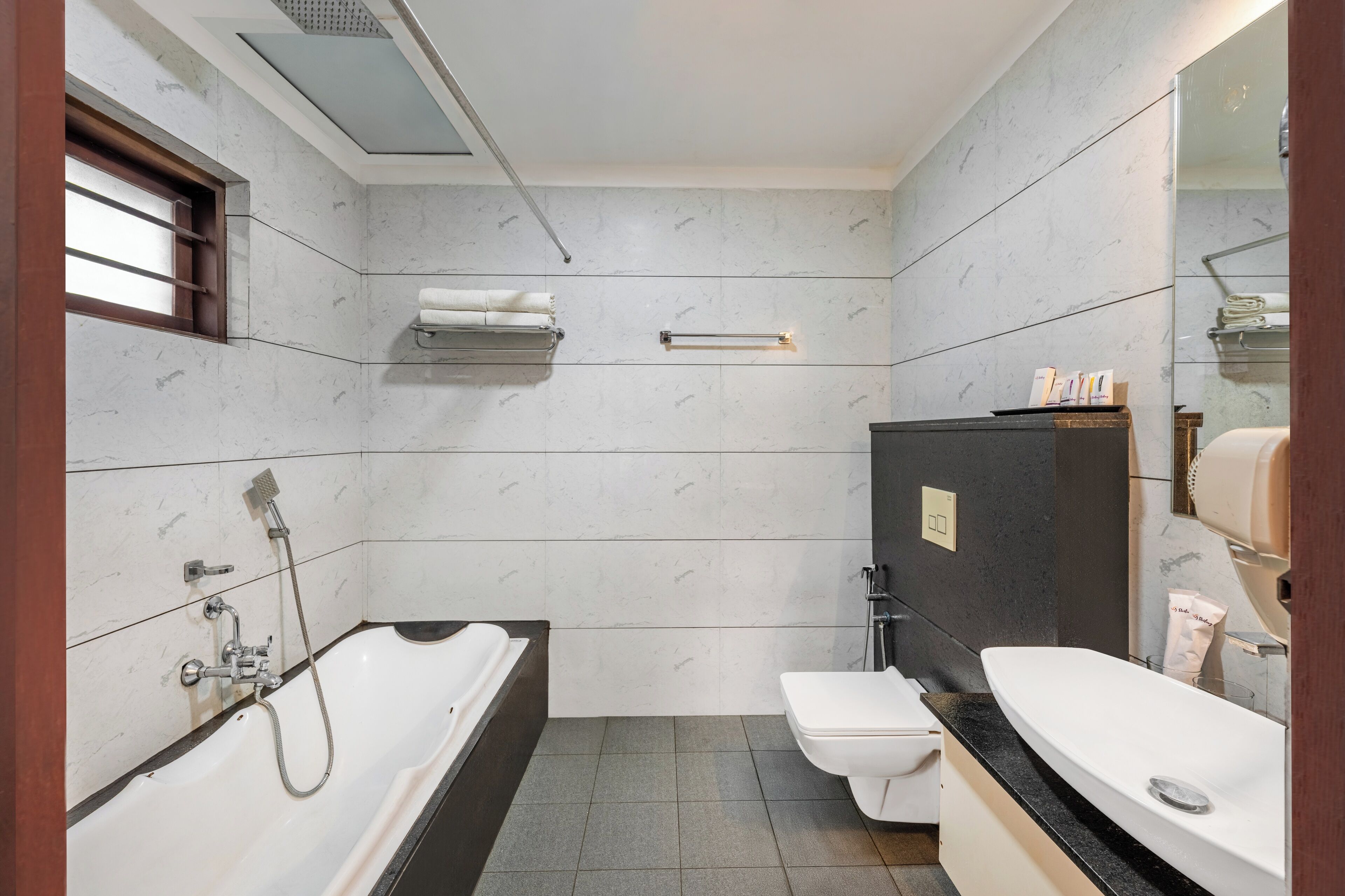 A modern bathroom with a bathtub, toilet, and sink.