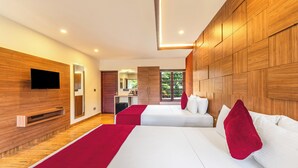 Ein modernes Hotelzimmer mit zwei Betten, einer Holzvertäfelung, einem Flachbildfernseher und Blick ins Freie.