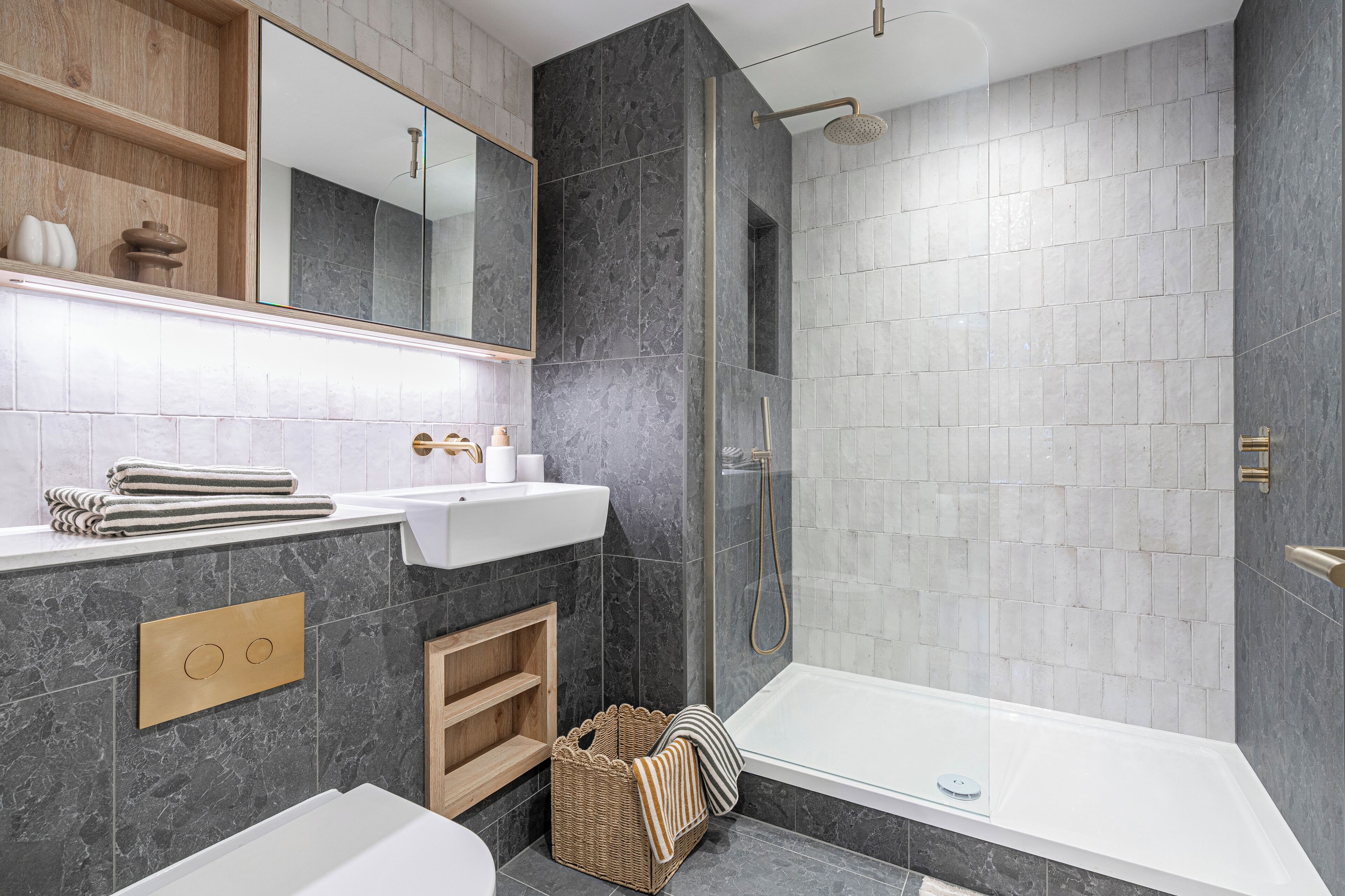 A modern bathroom with a bathtub, shower, and vanity.