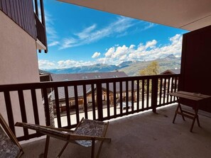 A balcony with a view of mountains and a clear sky. There are two wooden chairs and a small table on the balcony. - 130m from ski slopes, 2nd floor, view mountain, balcony, tv, ski locker, 24m², Peisey-Vallandry (Landry)