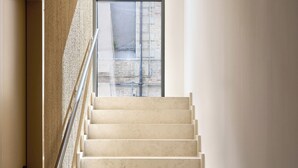 A staircase with a metal handrail leading to a window with a view of buildings outside. - G PALACE Residence (Civitanova Marche)