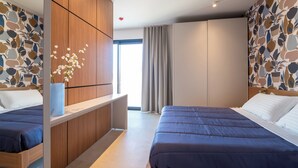 A modern bedroom with two beds, a wooden wardrobe, and a large window with curtains. - G PALACE Residence (Civitanova Marche)