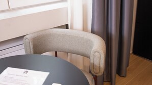 A modern room with a round table, a chair, a remote control, and a document on the table. - Milano Bene Suites (Milan)