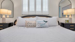 A neatly made bed with two pillows, a bedside table with a lamp, and a window with blinds. - Paradise Found Home With Private Heated Saltwater Pool And Cabana Plus Game Room (Seminole)