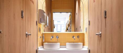 Un baño moderno con armarios de madera, lavamanos doble y un espejo sobre los lavamanos.