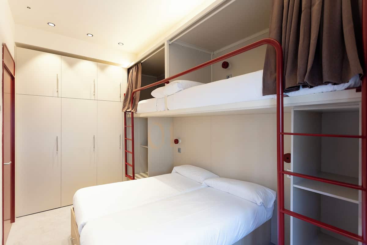 A bunk bed room with a wardrobe and a ladder.