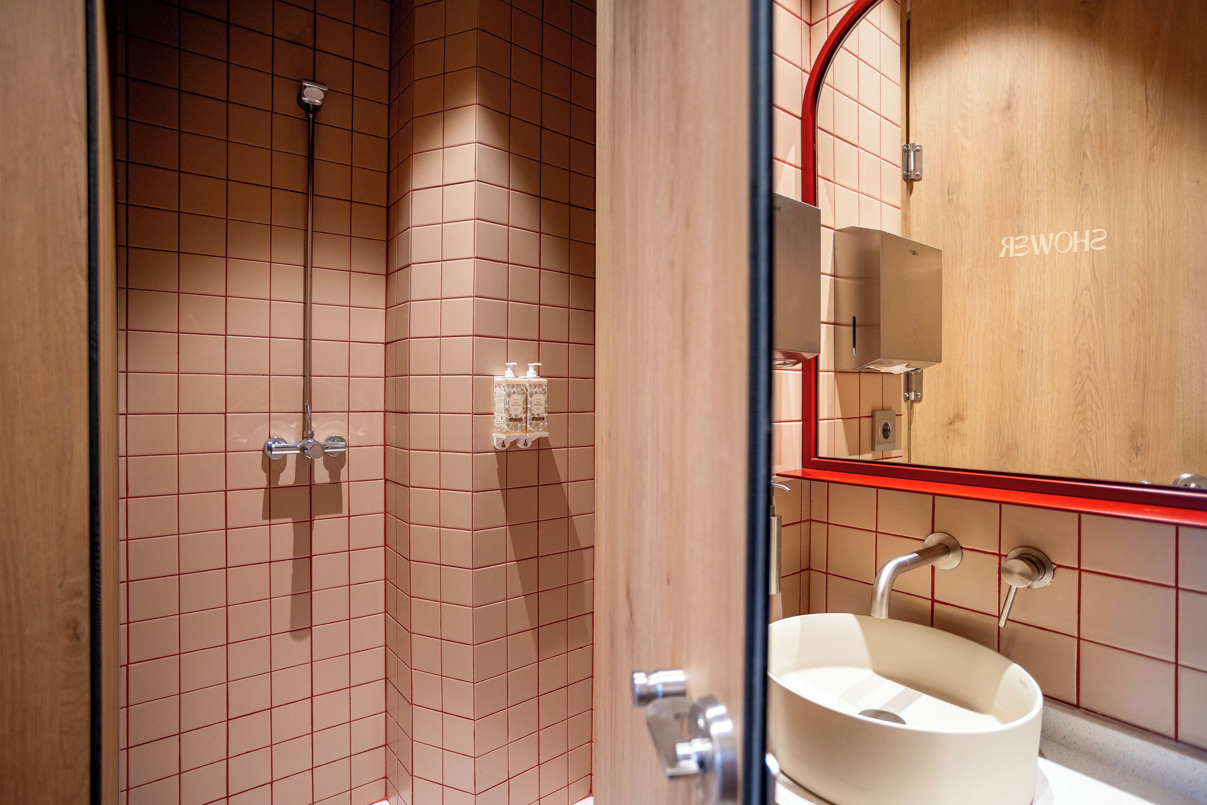 A modern bathroom with a shower, a sink, and a mirror.