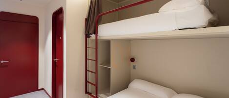 A bunk bed with a ladder, a red door, and a white wall.