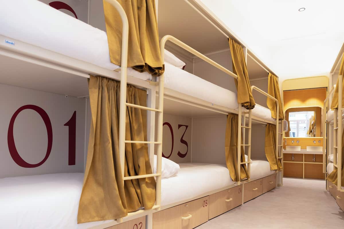 A bunk bed room with numbers on the walls, a small bathroom, and a window.