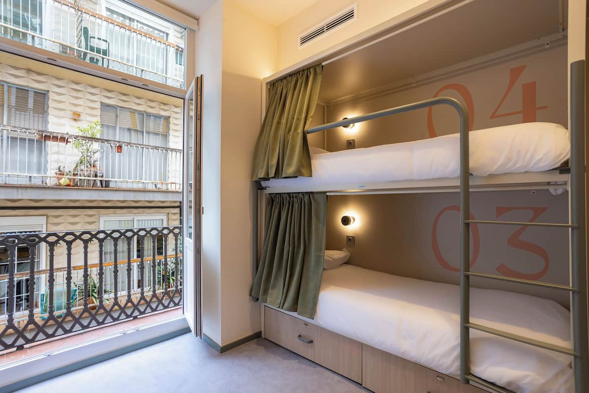 A bunk bed room with a window, a balcony, and a number '04' on the wall.