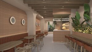 A modern interior with a long counter and seating area, featuring round tables and chairs, and a central island with a bar. - The Central House Valencia Mercado Central (Valencia)