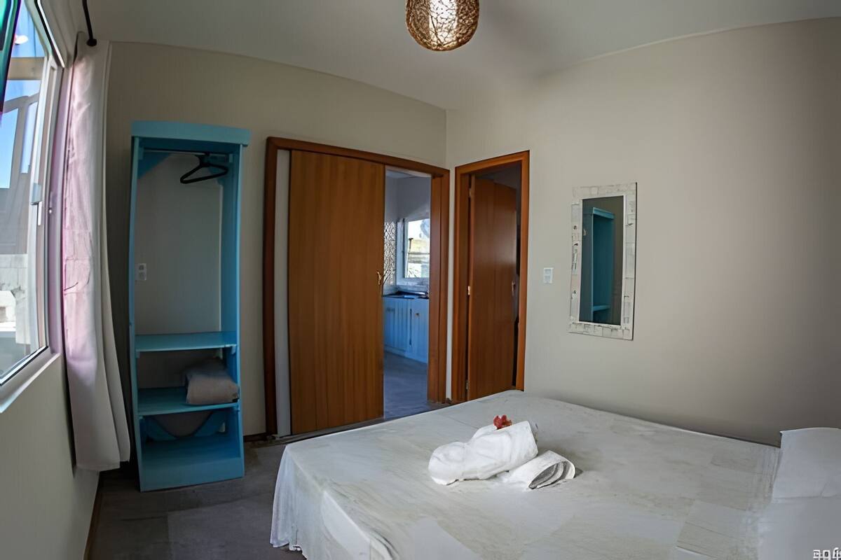 Une chambre à coucher avec un lit, une armoire et un miroir.