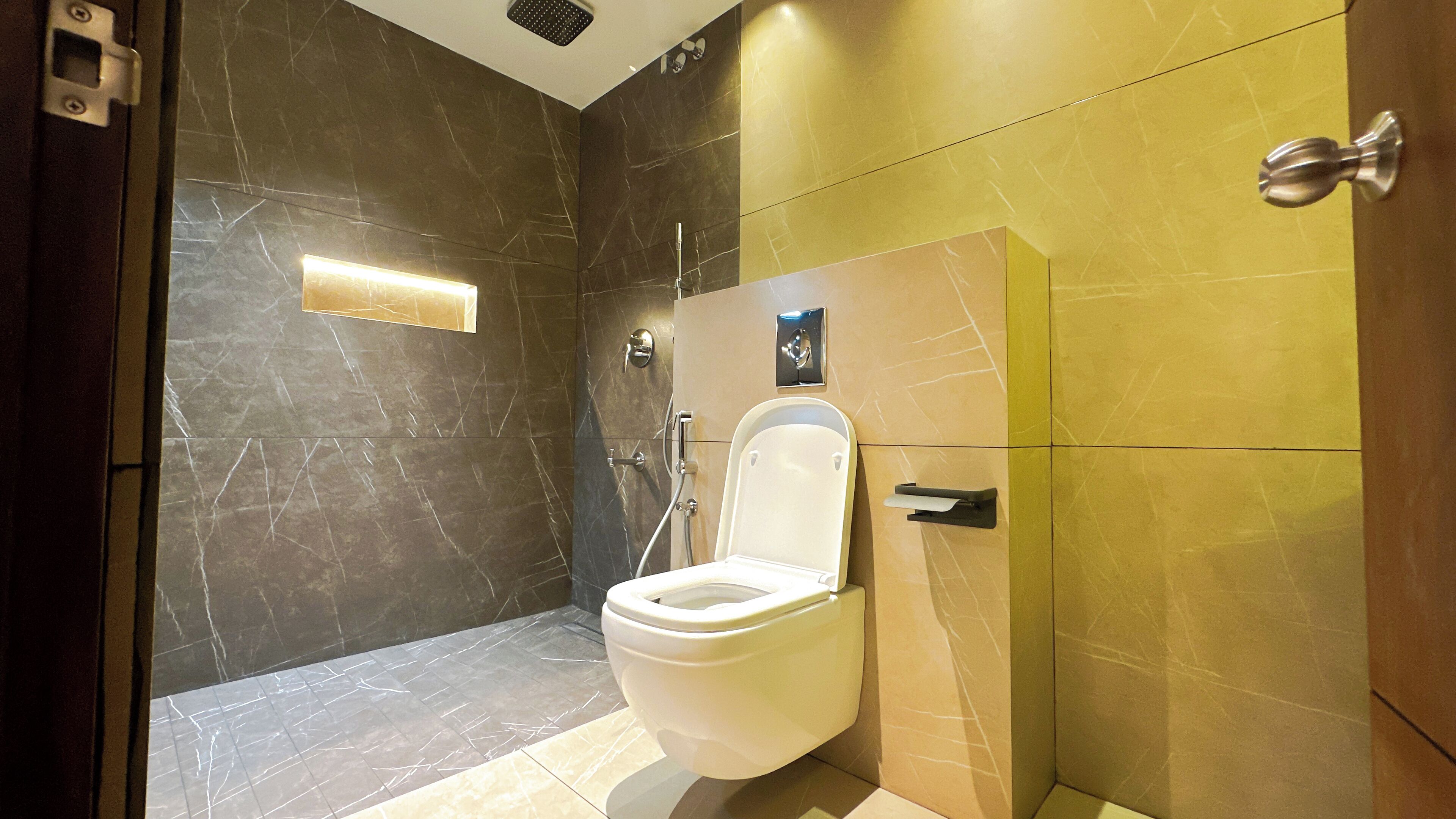 Ein modernes Badezimmer mit Toilette, Duschbereich und Marmorboden.