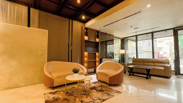 Un intérieur moderne avec un canapé, des fauteuils, une petite table et un tapis décoratif.