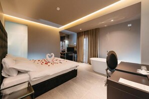 A modern hotel room with a large bed, a vanity with a mirror, and a separate bathroom. - Hotel Egnatia (Kashar)