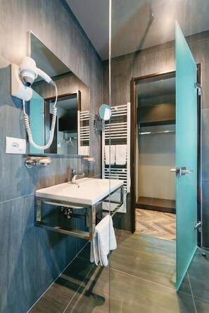 A modern bathroom with a large mirror, a hairdryer, a towel rack, and a shower area. - Hotel Egnatia (Kashar)