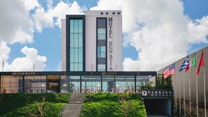 Un hotel con facciata moderna, un ristorante e un'area parcheggio.