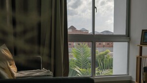 A room with a large window, a bed, and a small wooden shelf. -  White Sand Beach Retreat (Punta Cana)