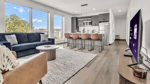 Un appartement moderne comprenant un salon, une cuisine et un coin repas.
