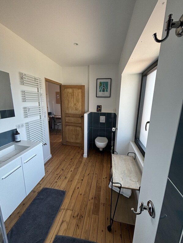 A compact bathroom with a toilet, a sink, and a shower area.