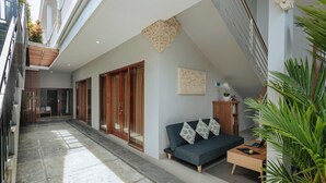 Ein modernes Interieur mit einer Couch, einem Holzschrank und einer Pflanze.