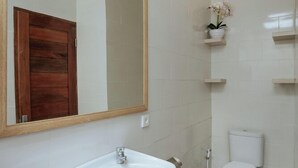 Ein Badezimmer mit Waschbecken, Spiegel, Toilette und Dusche.