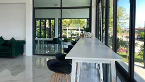 A modern interior with a long white table, black chairs, and a green sofa. - Tree Airport Hotel Hatyai (Khuan Lang)