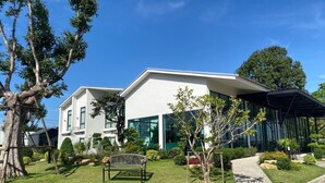 A modern building with a white facade, large windows, and a covered outdoor area. - Tree Airport Hotel Hatyai (Khuan Lang)
