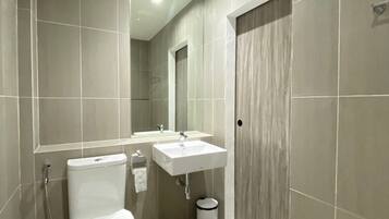 Un baño moderno con inodoro, lavabo y ducha.
