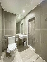 Un baño moderno con inodoro, lavabo y ducha.