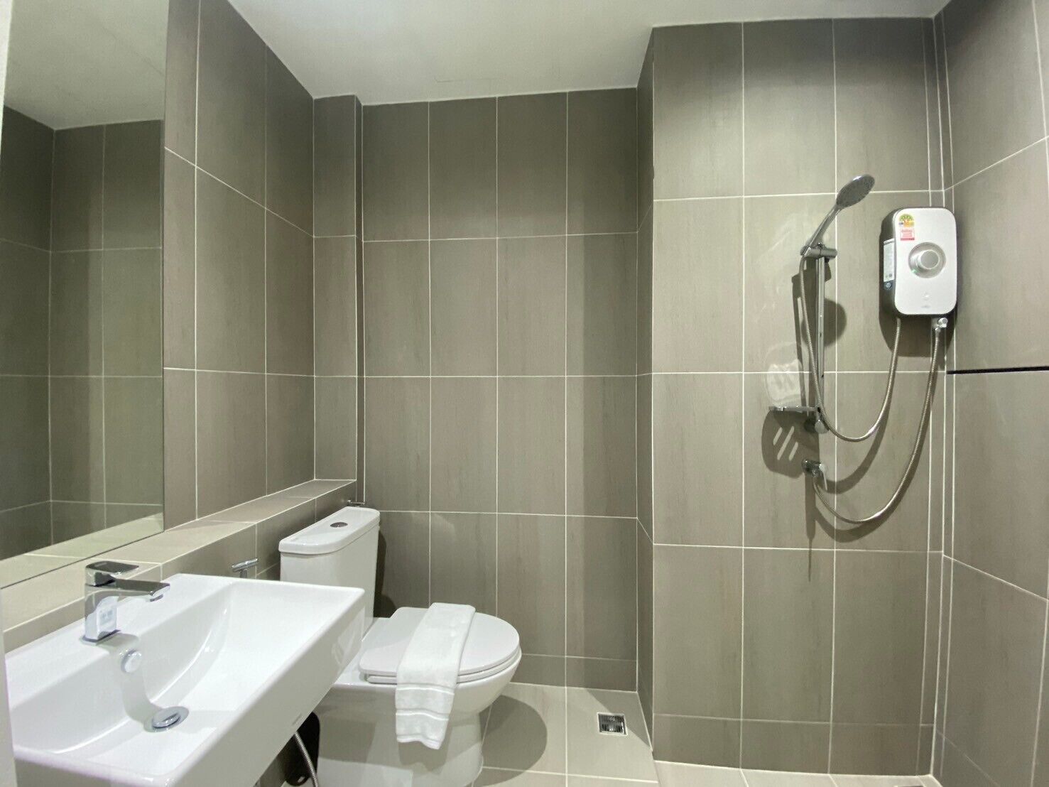 A modern bathroom with a white sink, toilet, and shower.