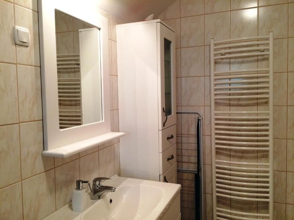 Une salle de bain équipée d’un lavabo, d’un miroir, d’un meuble et d’un porte-serviettes.