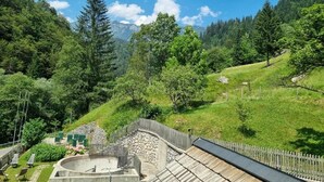 Un paisaje montañoso con una terraza de madera y una estructura de piedra.